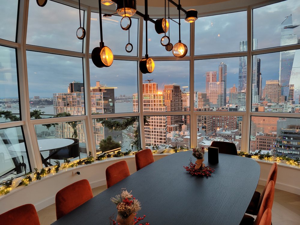 High-rise conference room featuring floor-to-ceiling glass windows framing sweeping Manhattan skyline and