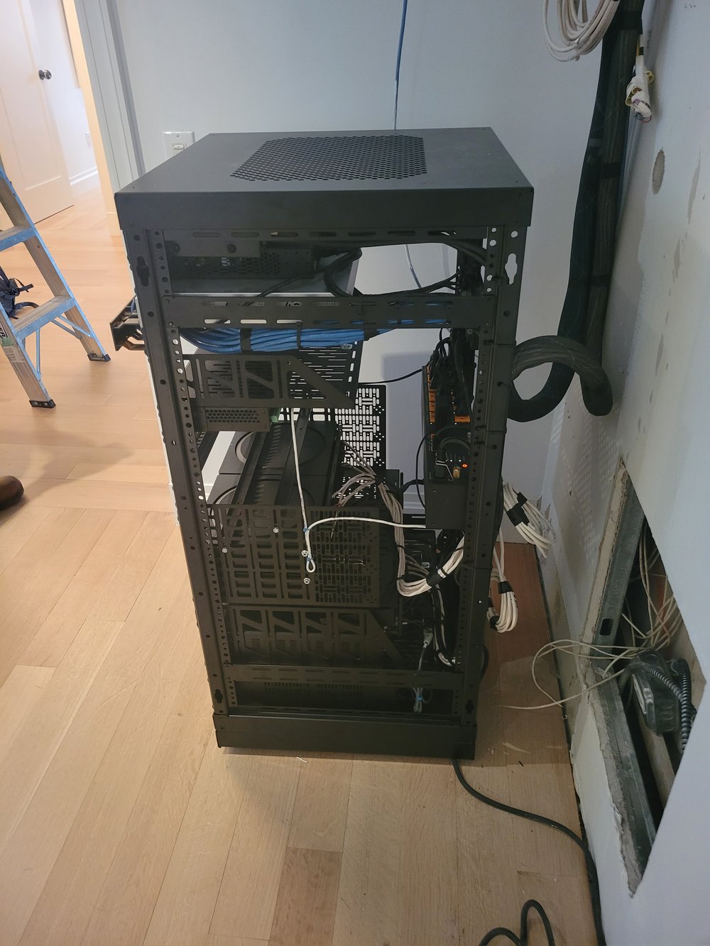 An open-door view of a partially assembled server or equipment cabinet showing internal infrastructure. The