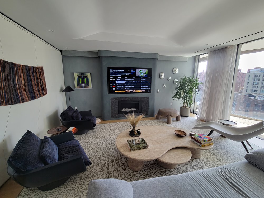 High-end media room/living room showcasing a completed smart-home installation with stunning NYC skyline city