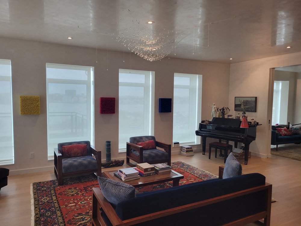 Elegant high-rise living room featuring a gloss ceiling with embedded crystal chandelier as focal point.