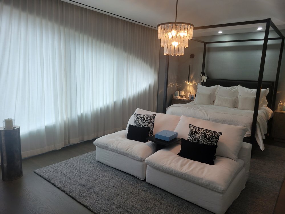 Closer view of the luxury bedroom focusing on the canopy bed, high-end linens, decorative pillows with