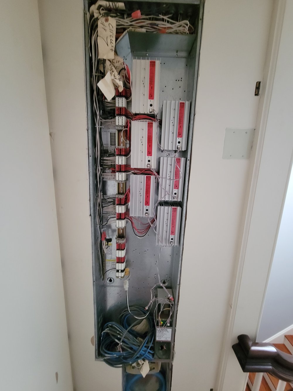 An in-progress interior photograph showing an electrical panel installation with multiple breakers and