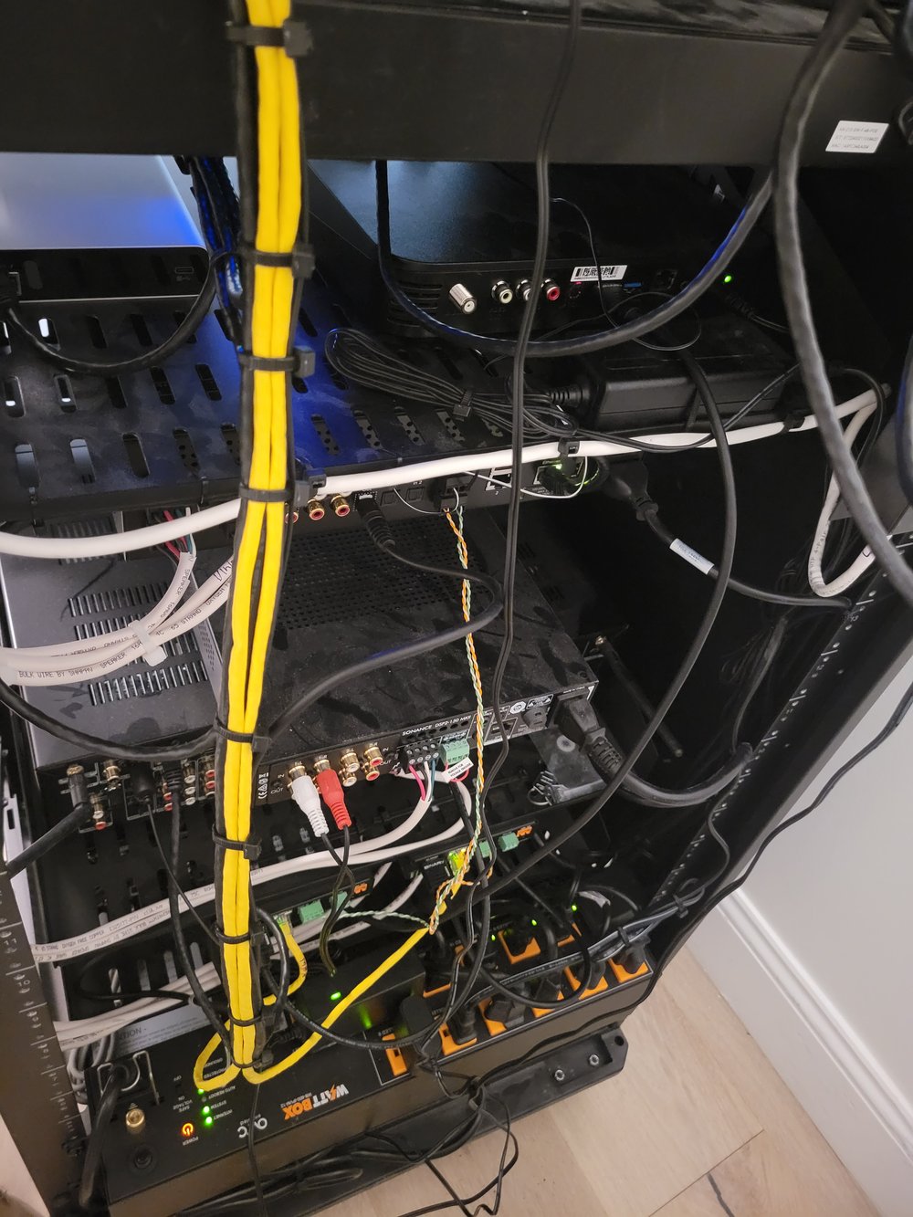A detailed view of audio/video equipment rack internals showing multiple components, blue audio connections
