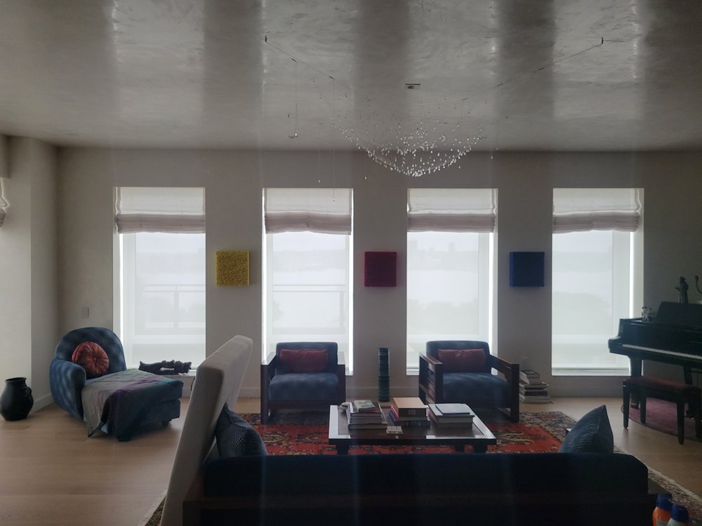 A transitional interior-exterior space with floor-to-ceiling motorized roller shade system, large