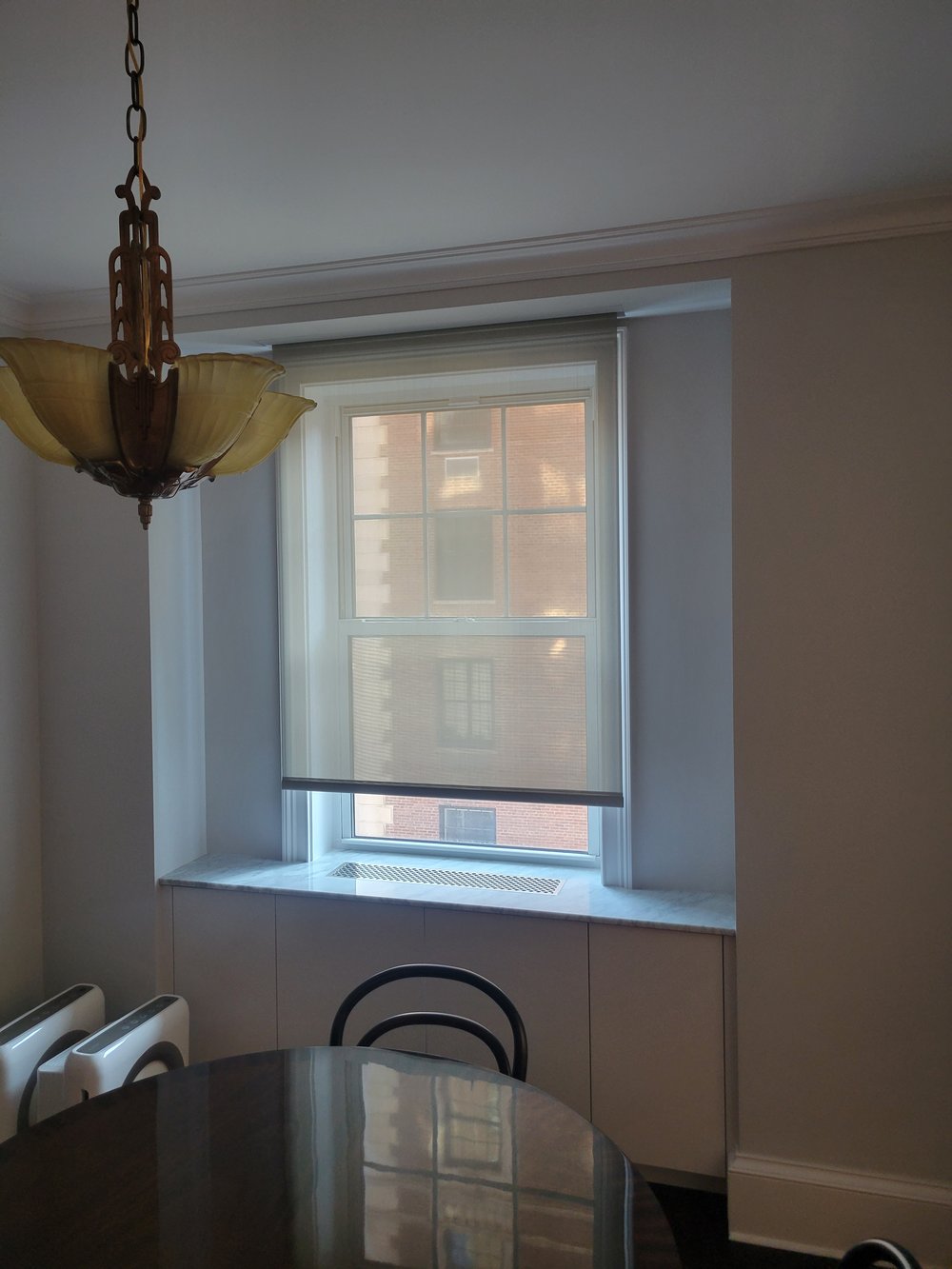 Kitchen or dining area detail photographed during daytime with prominent vintage-style pendant light fixture