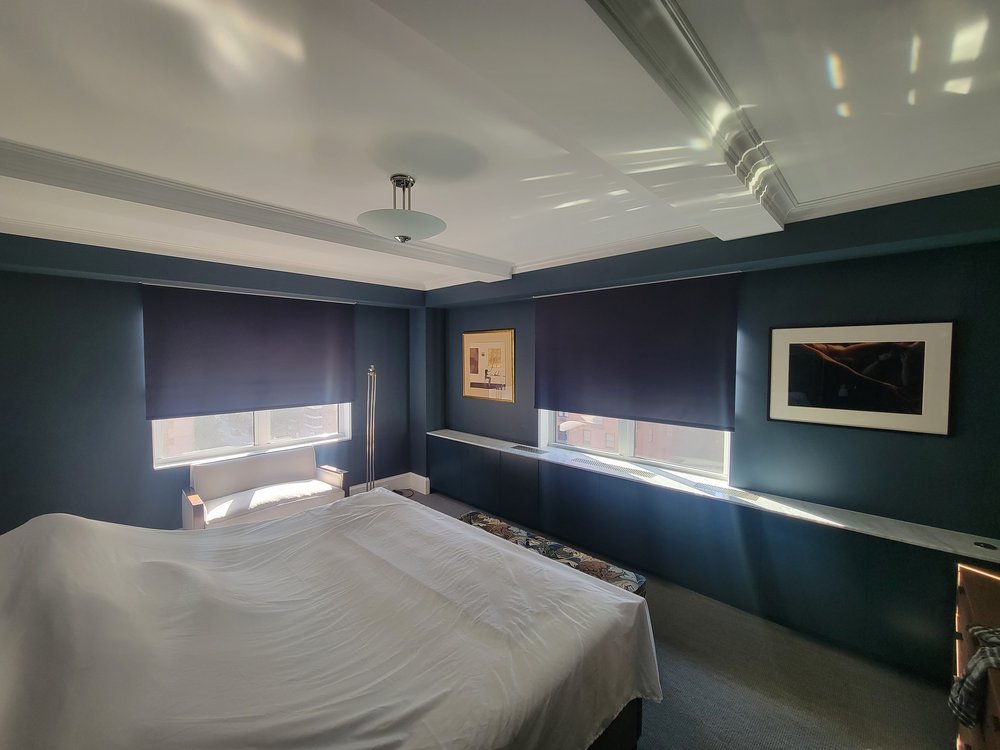 Modern bedroom with sophisticated dark color scheme featuring deep teal or forest green wall paint that