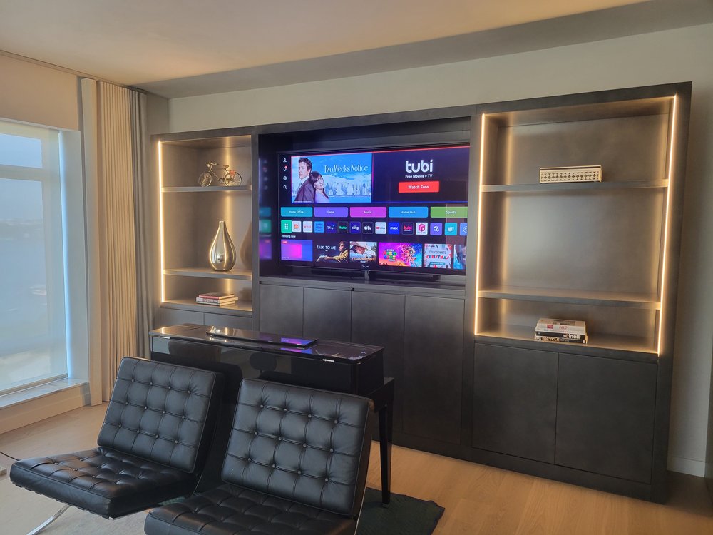 Luxury entertainment wall installation in a contemporary living space featuring extensive built-in shelving