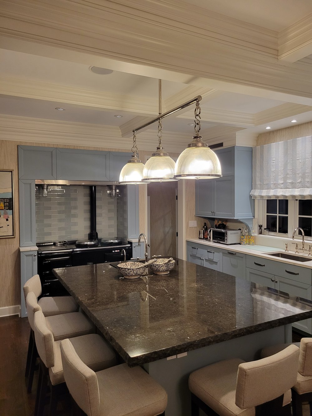 A luxurious finished kitchen featuring modern minimalist design with light gray cabinetry and natural wood