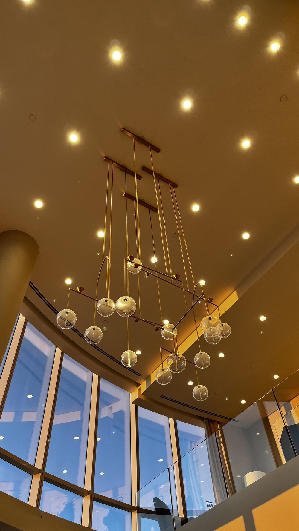 A stunning high-end luxury interior featuring an architectural pendant chandelier suspended from a