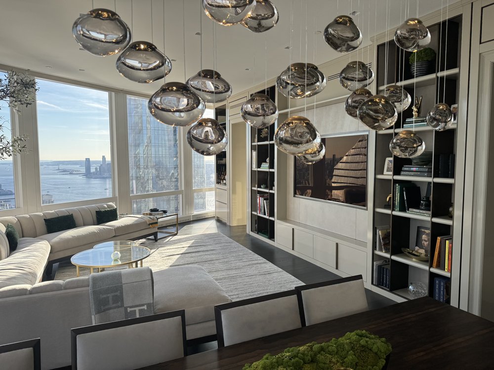 Sophisticated residential living and dining area with floor-to-ceiling windows overlooking Manhattan