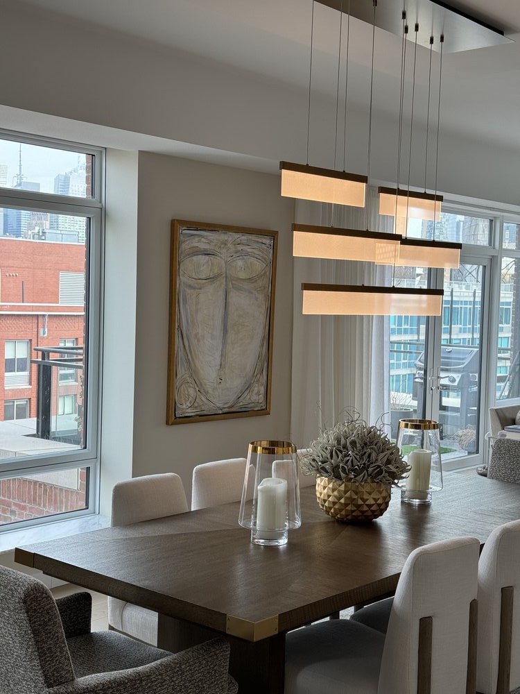 Modern bedroom featuring a contemporary gray armchair, expansive windows with motorized roller shades