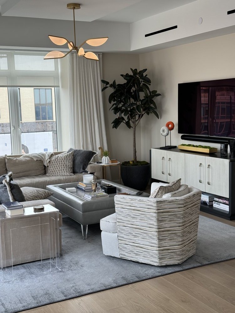 Modern bedroom with contemporary design featuring a white and gray patterned comforter, striped upholstered
