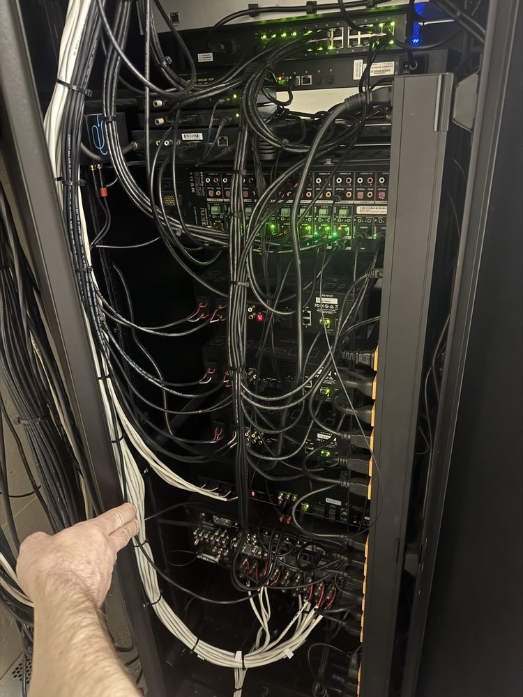 Technical installation photograph showing complex network and control system cabling within an equipment rack