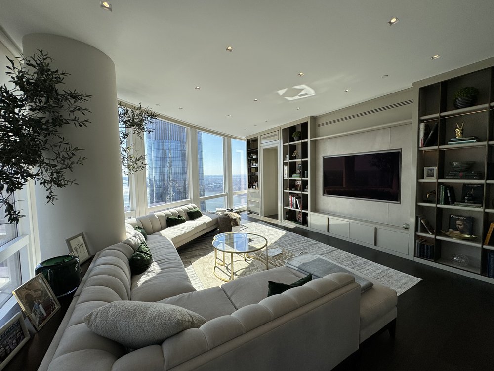 Exceptional high-rise residential living room with panoramic floor-to-ceiling windows displaying spectacular