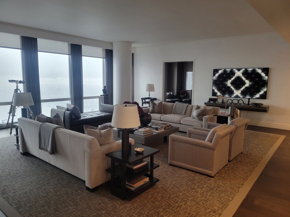 Luxury high-rise living room showcasing coordinated interior design with multiple seating zones. The space
