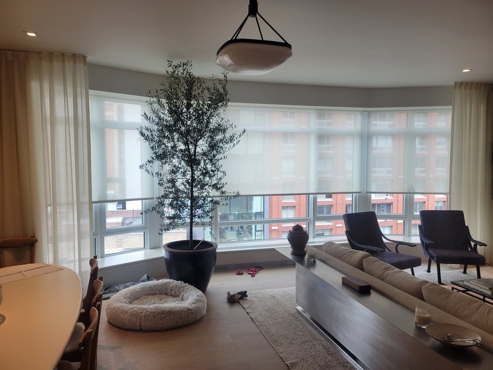 Sophisticated living room in a high-rise apartment with expansive city views. The space features