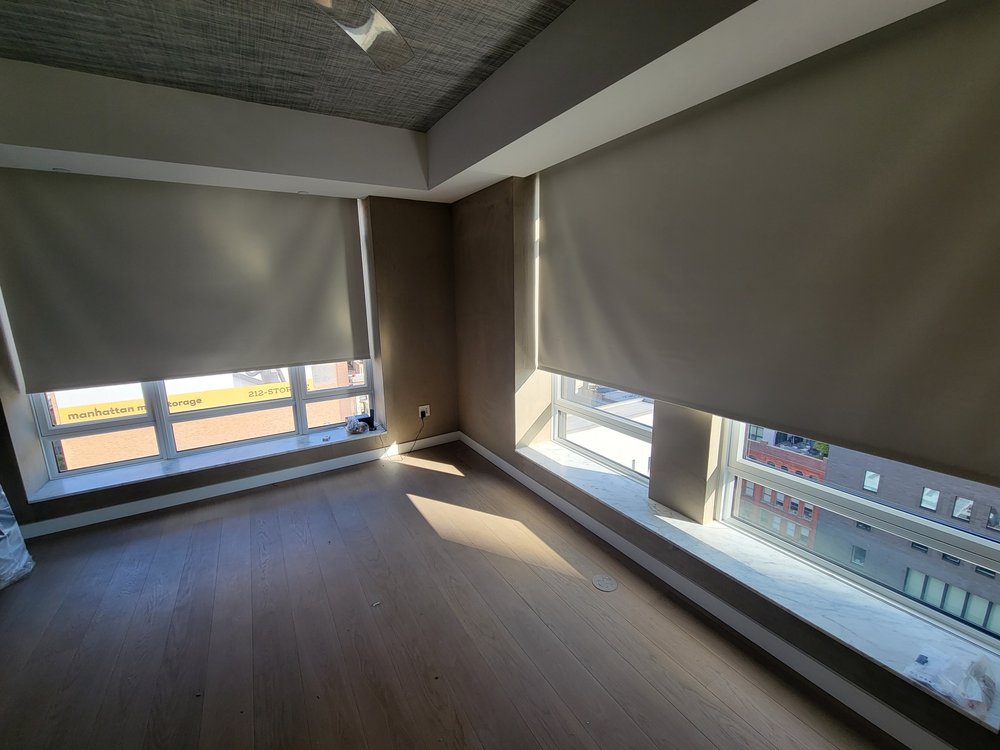 High-rise residential apartment with commanding floor-to-ceiling windows showcasing expansive city views. The