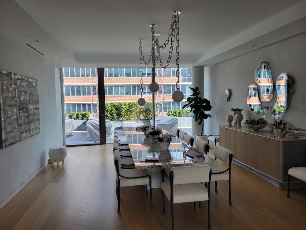 Luxurious dining space in a high-rise tower with panoramic city views of brick apartment buildings. A