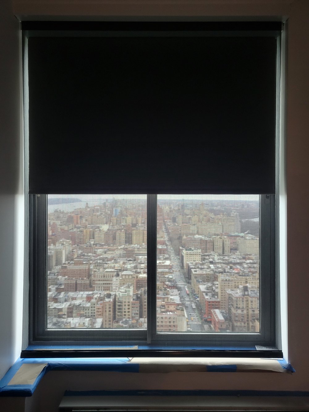 Polished high-rise window installation featuring a sophisticated motorized shade system with dual-layer