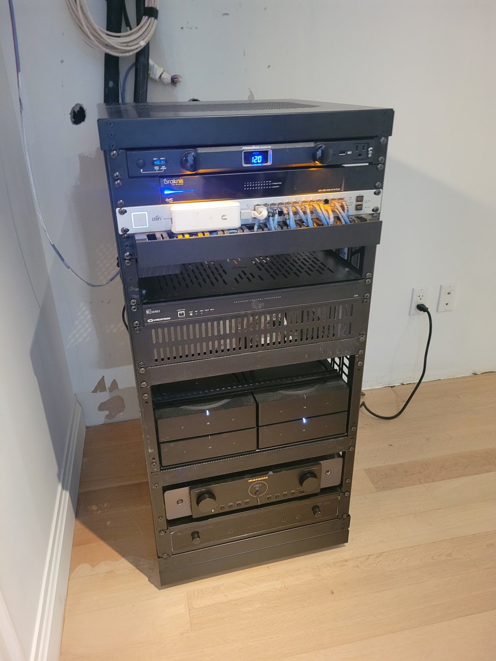 A professional equipment rack installation photograph showing multiple layers of AV and control systems.