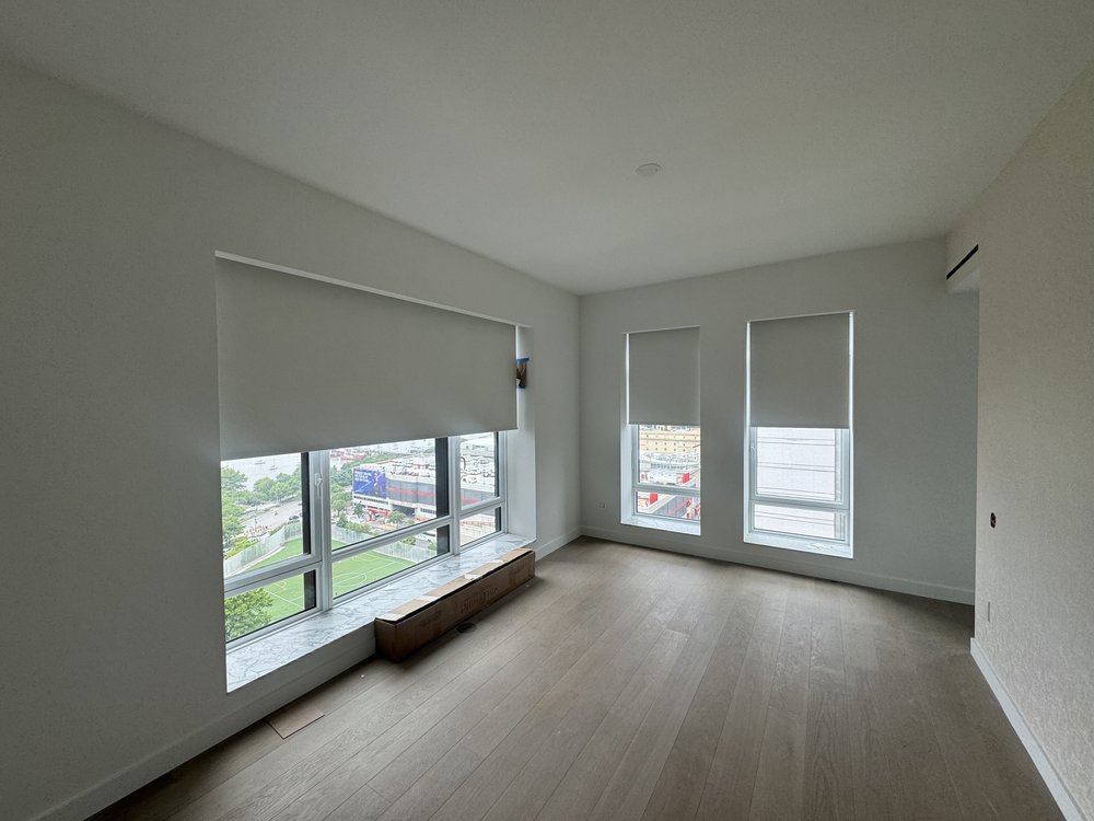Finished contemporary living space with premium motorized window shades and sophisticated lighting