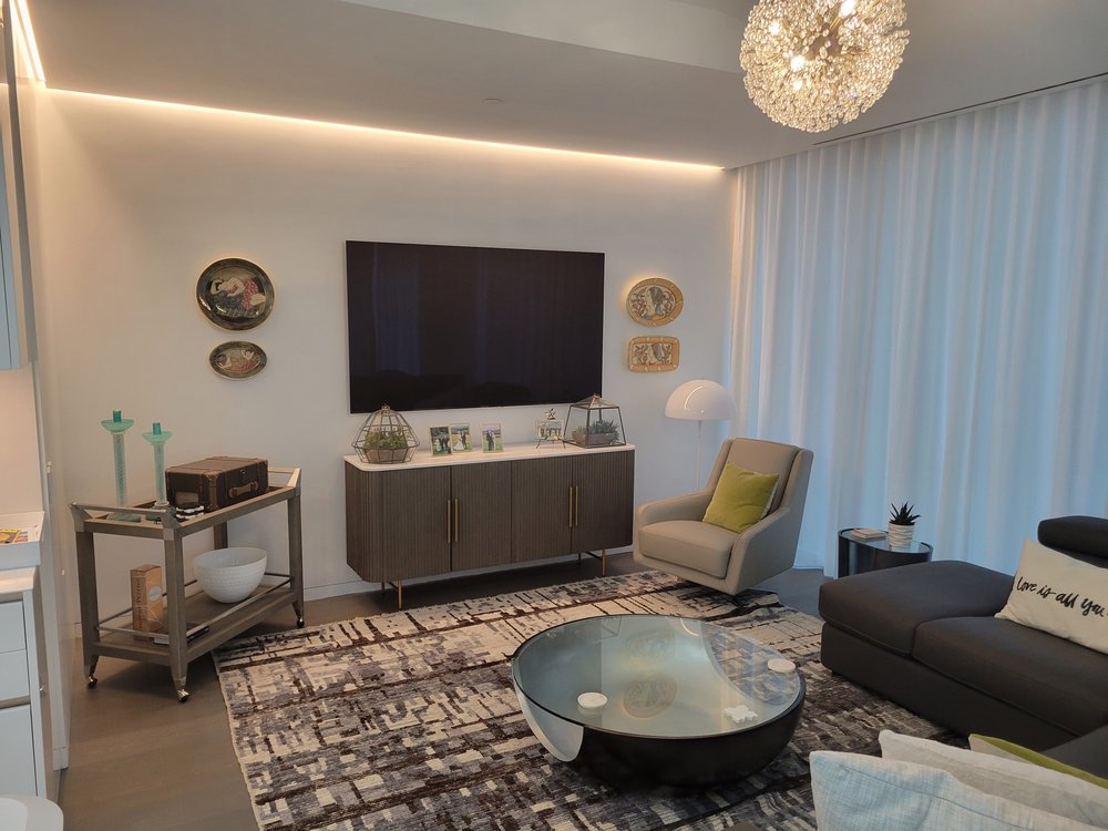 Contemporary living room centered on a wall-mounted TV flanked by decorative circular brass-framed plates.