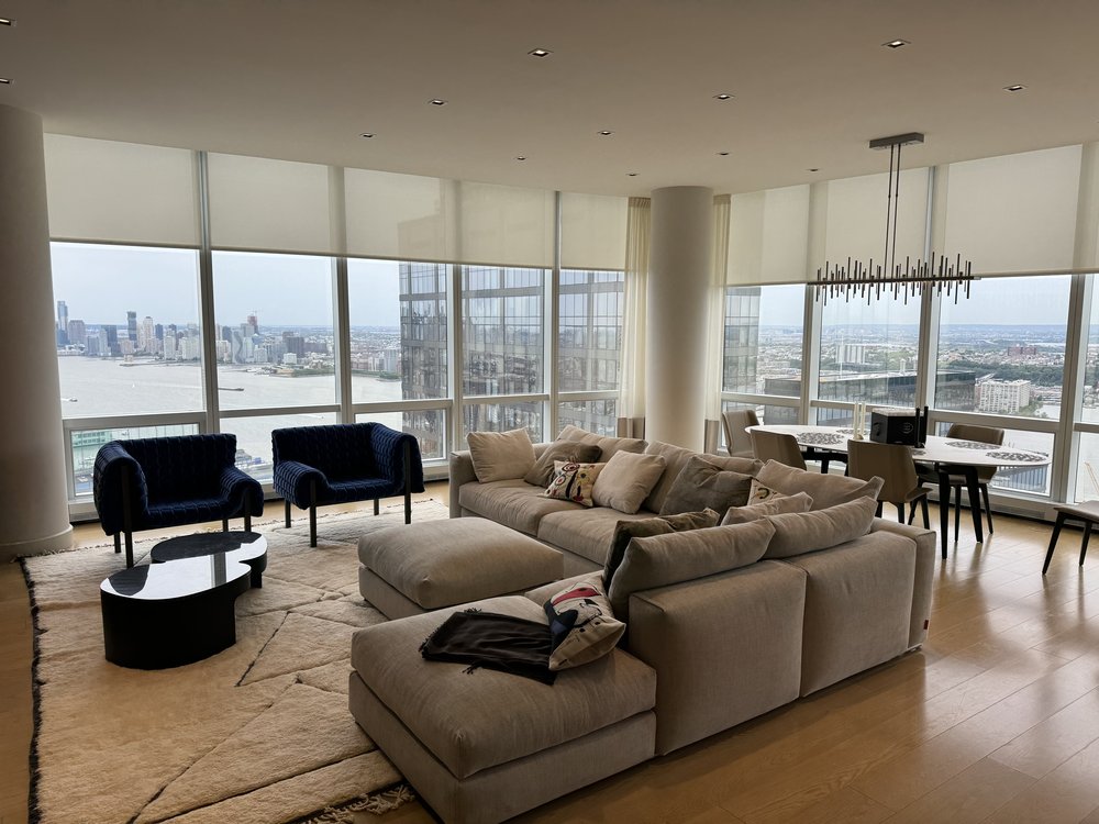 Ultra-premium penthouse living room with spectacular floor-to-ceiling windows overlooking the Manhattan