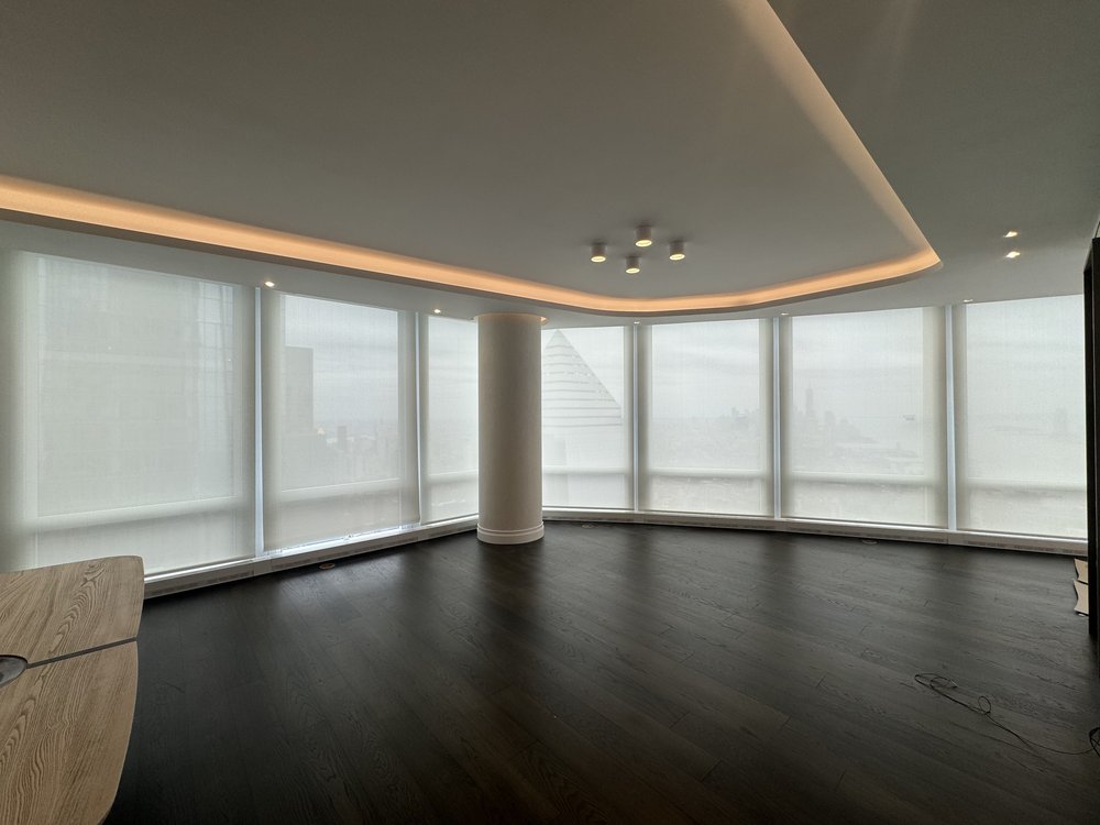 Outdoor terrace or rooftop space featuring a large outdoor television/display mounted on a wall. The space is