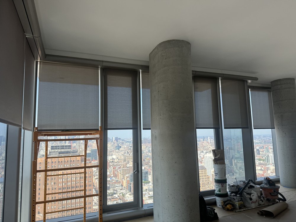High-rise residential unit with motorized roller shades installation and stunning panoramic city skyline