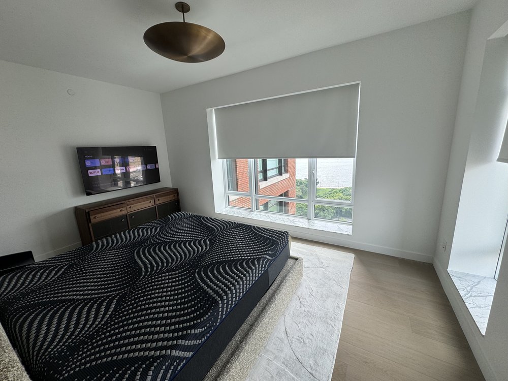 Finished master bedroom with integrated home automation and sophisticated lighting design. The space features