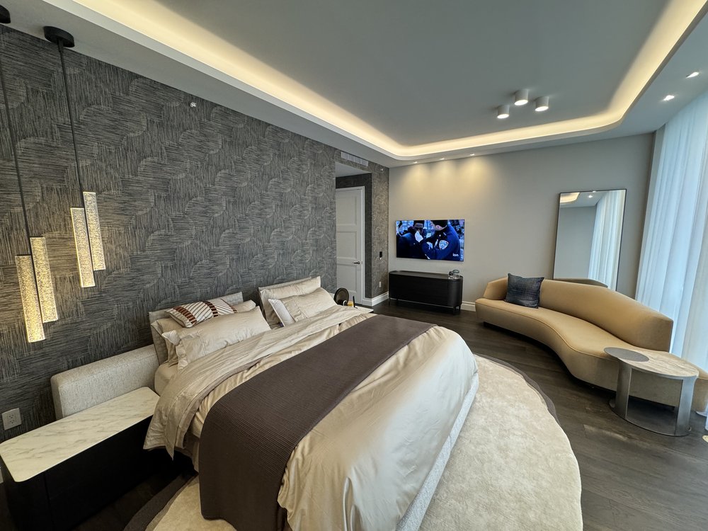 Sophisticated master bedroom combining luxury hotel aesthetics with residential comfort. Dramatic striped