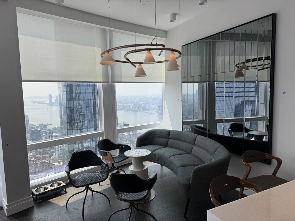 High-rise executive office or residential lounge space with sweeping panoramic windows showcasing Manhattan