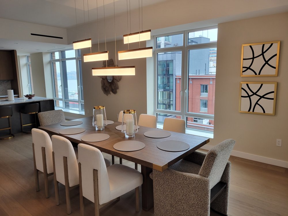 Matching view of the contemporary dining room with long dark wood table and cream upholstered chairs.