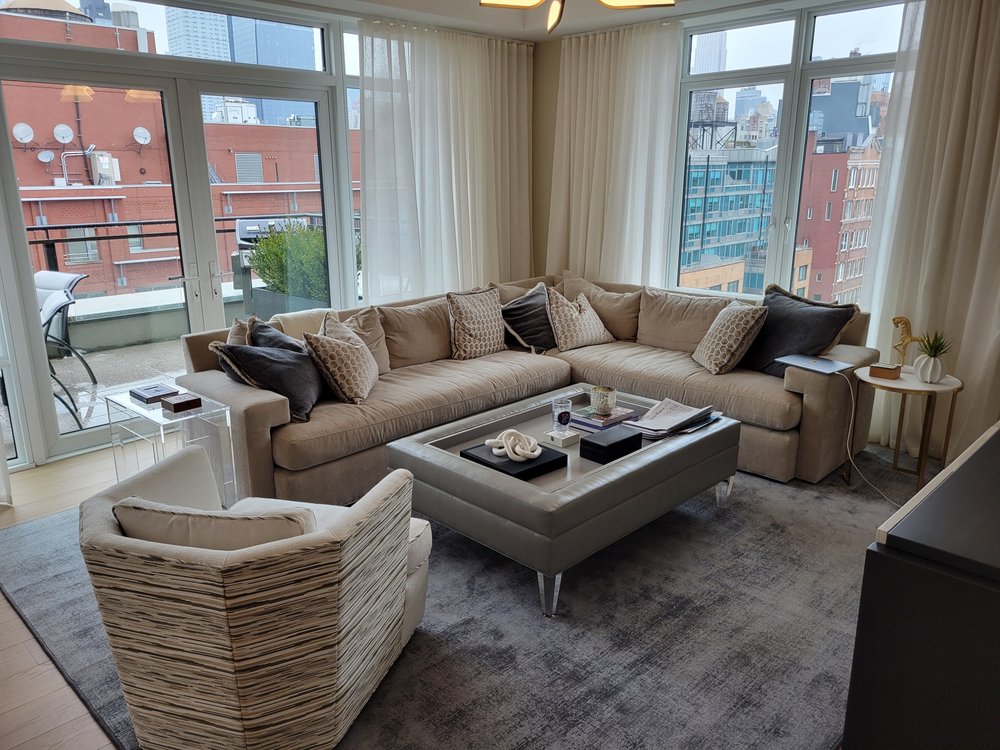 Finished luxury living room in a NYC high-rise with expansive city views through oversized corner windows