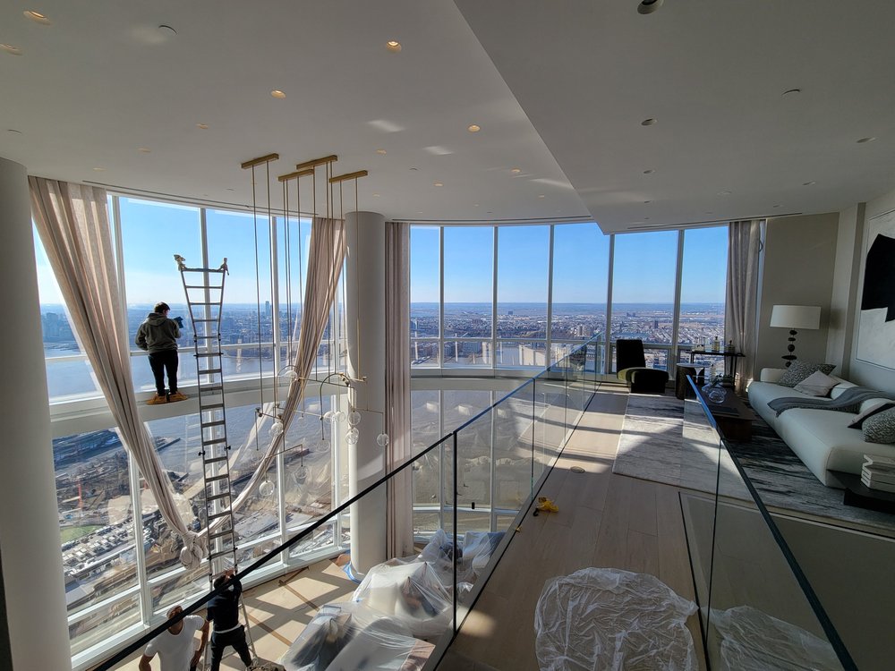 A luxurious high-rise apartment bedroom during final construction phases with protective plastic sheeting on