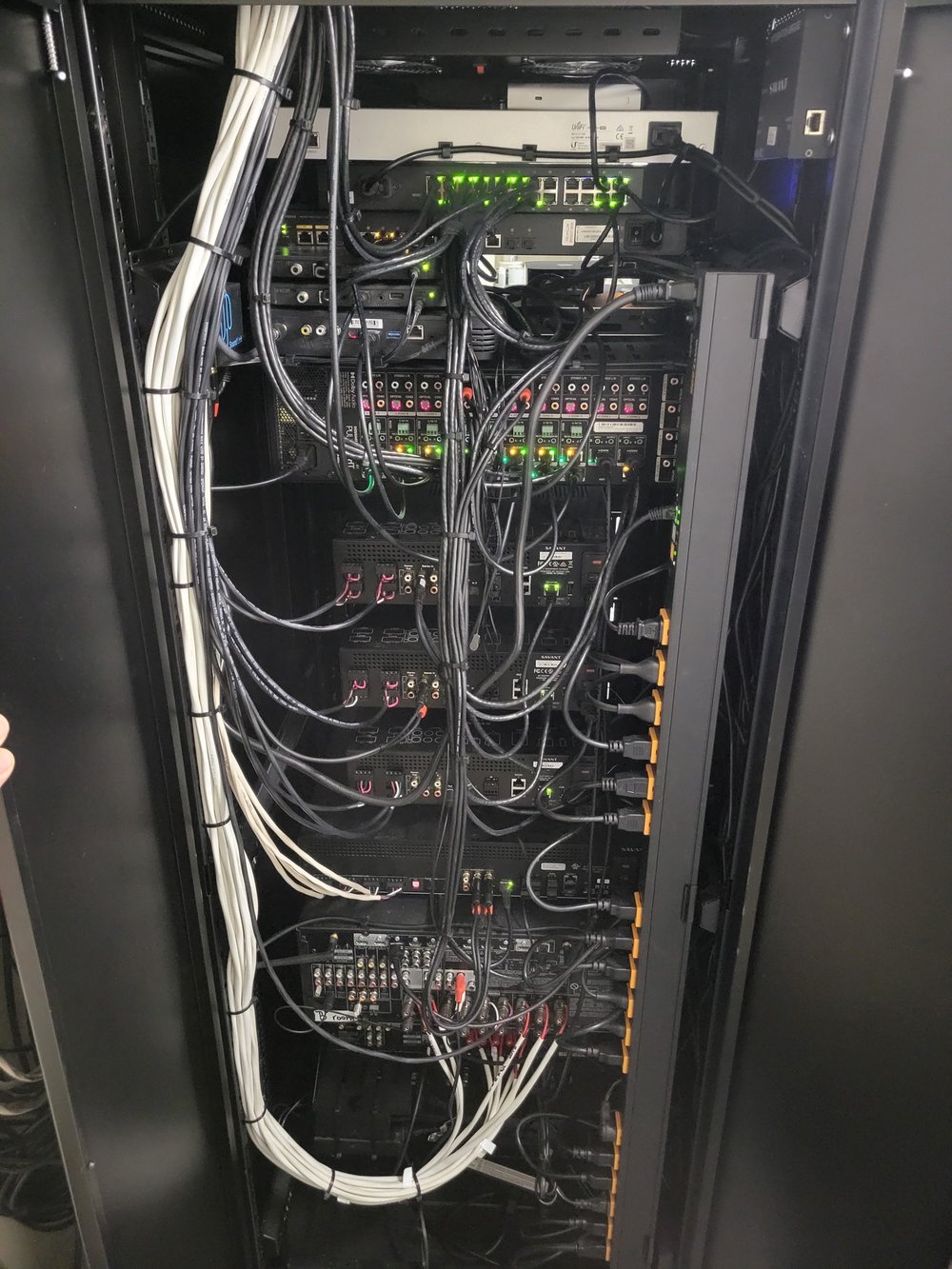 An open equipment rack showing dense internal cabling infrastructure with white bundled cables, networking