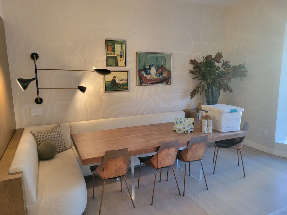 Contemporary dining space with sculptural wall-mounted lighting fixture featuring articulated black arms and