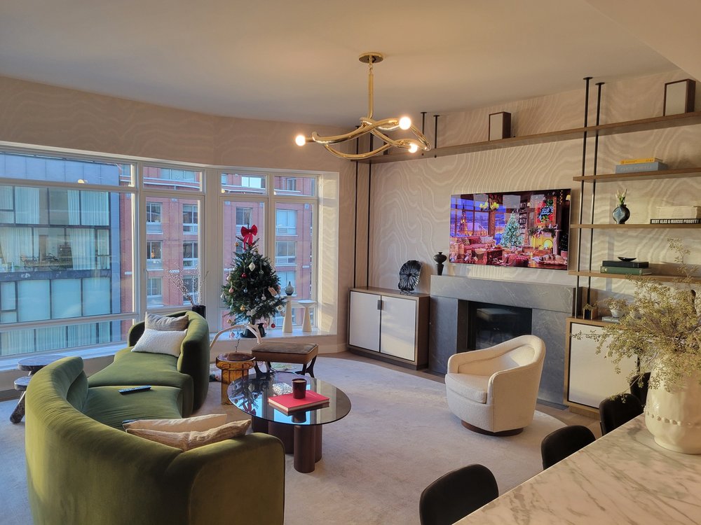 High-end modern living room with floor-to-ceiling windows offering expansive city views, featuring a curved