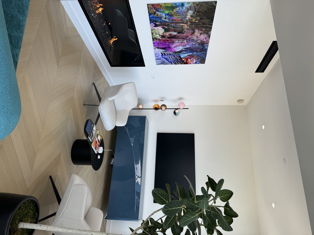 Living room from alternative angle showcasing turquoise sectional sofa with navy pillows, wall-mounted