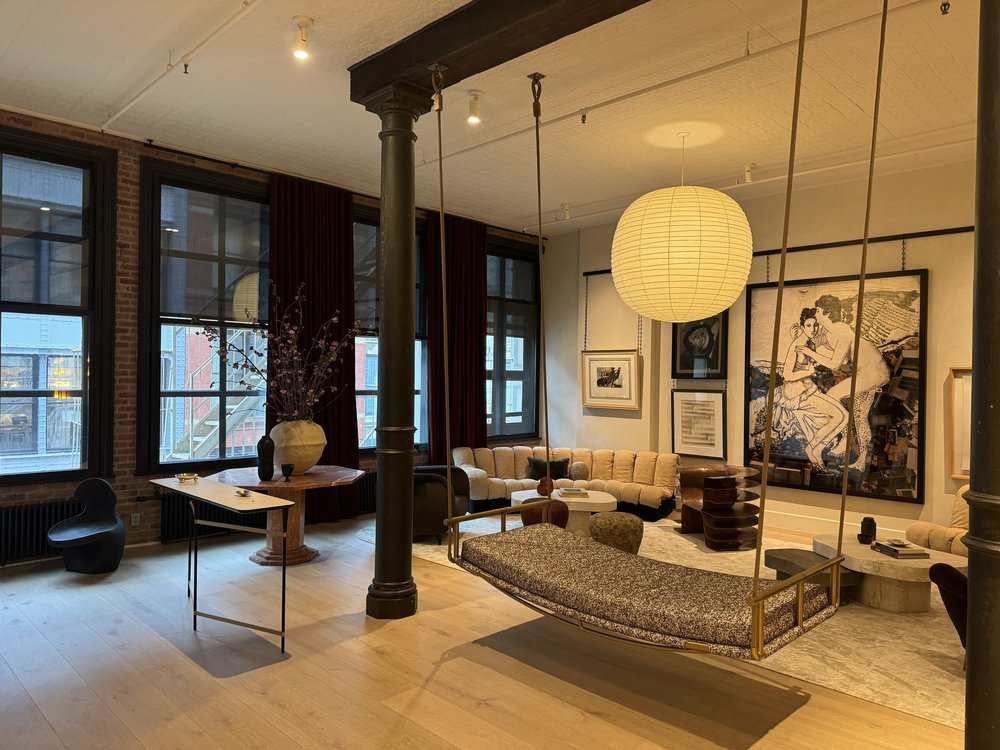 Sophisticated loft-style living room with exposed brick and industrial column, large pendant light fixture