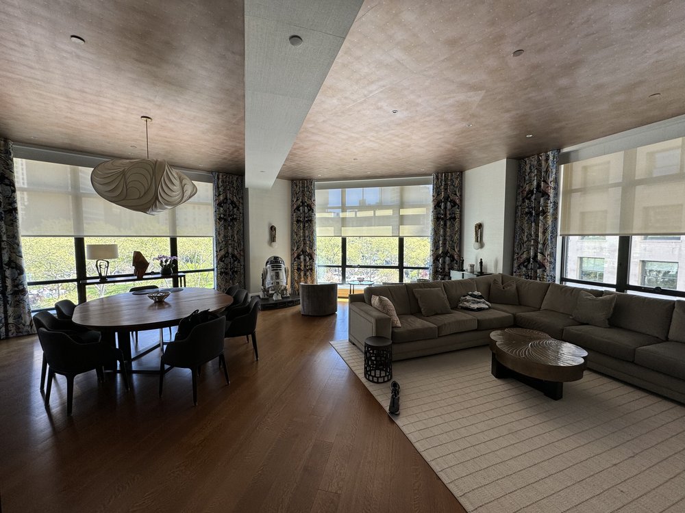 Expansive high-end residential loft with vaulted ceilings, exposed wood beaming, sculptural pendant