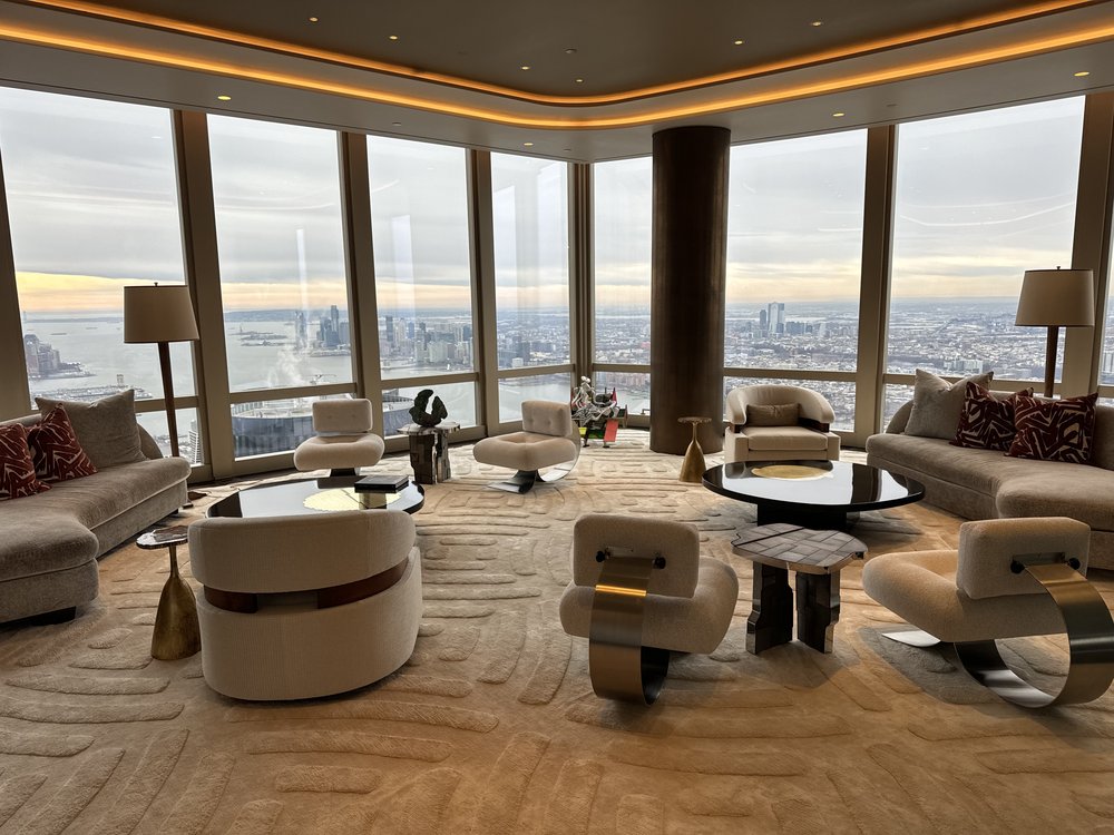 Spectacular luxury high-rise living room with 180-degree floor-to-ceiling window views of Manhattan skyline