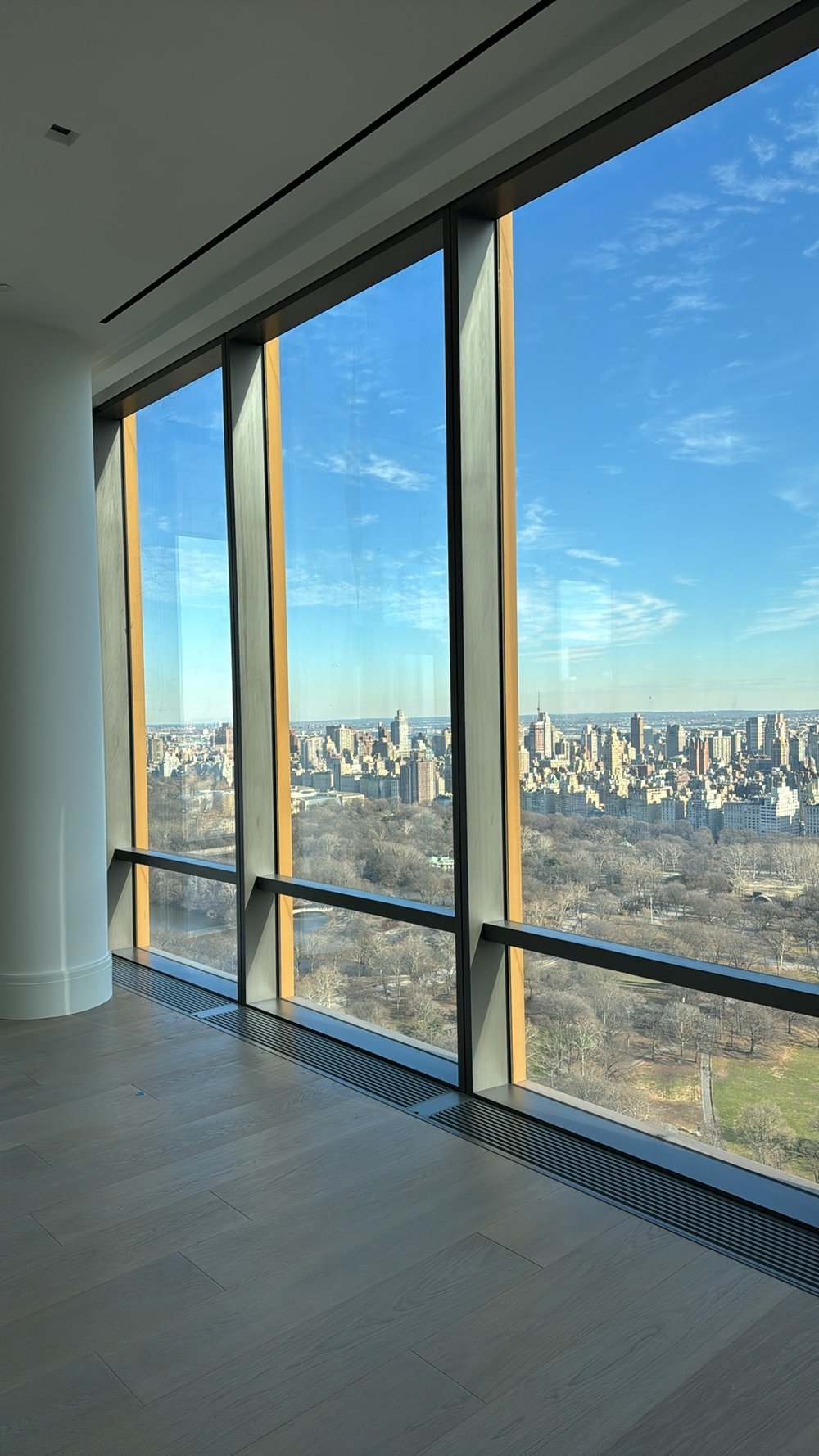 Stunning high-rise interior featuring dramatic floor-to-ceiling windows with motorized roller shades in