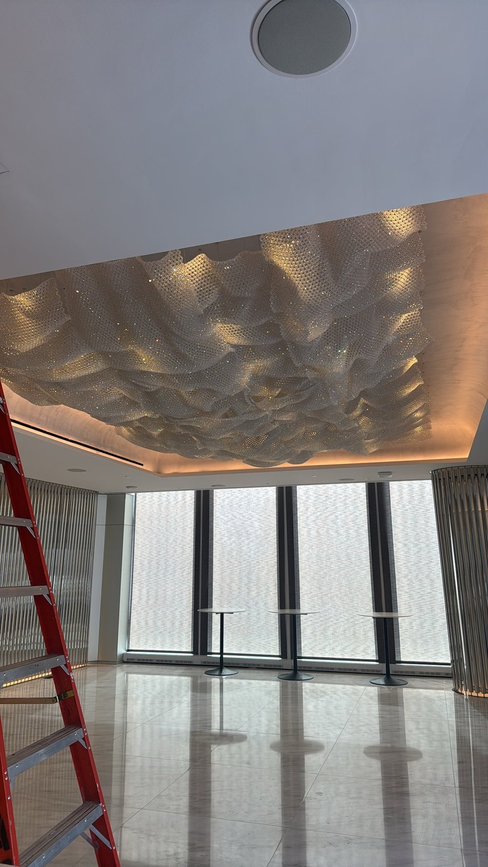 Contemporary commercial lobby or gallery space with dramatic sculptural textured ceiling featuring integrated