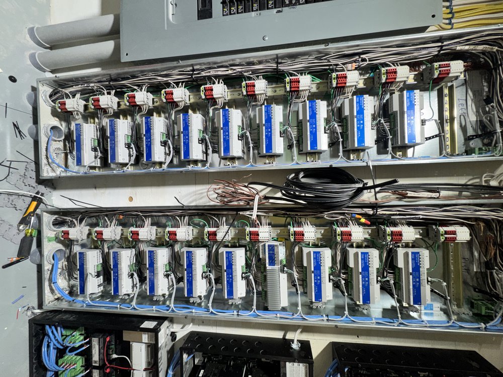 Overhead view of a professional electrical/lighting control panel installation featuring two rows of