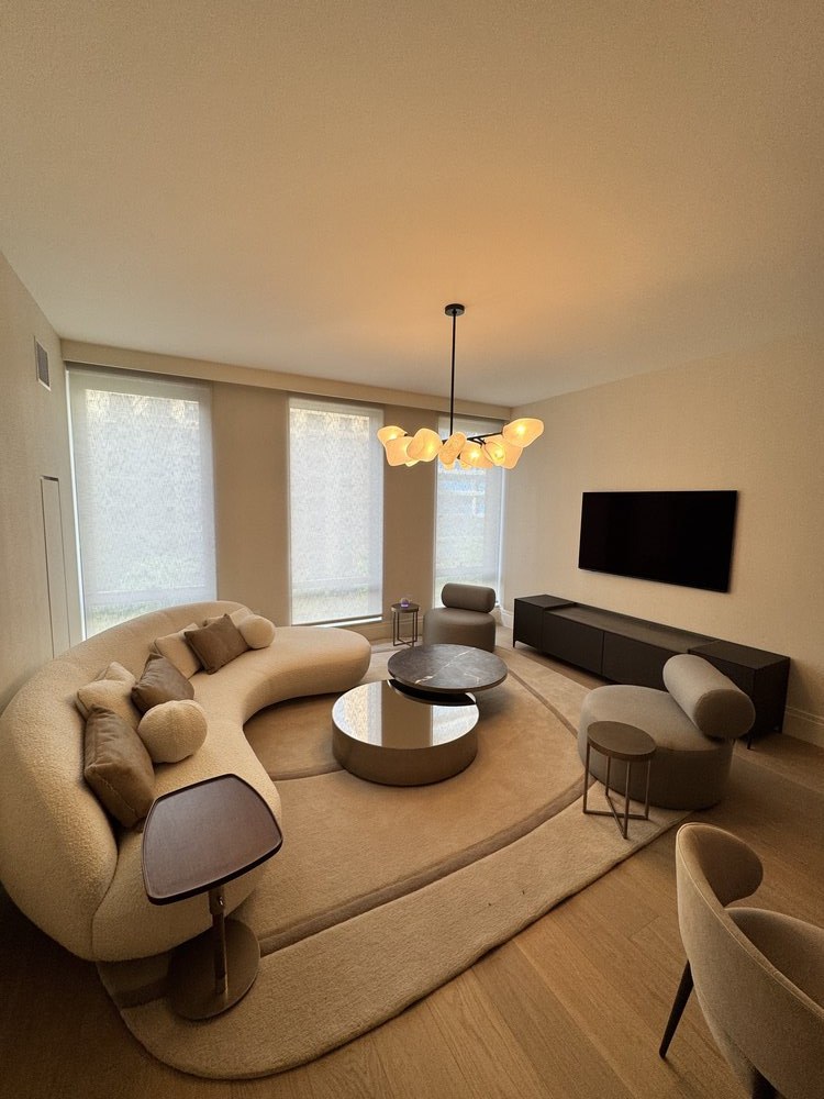 Overhead view of a luxury living room interior featuring curved cream-colored upholstered seating with