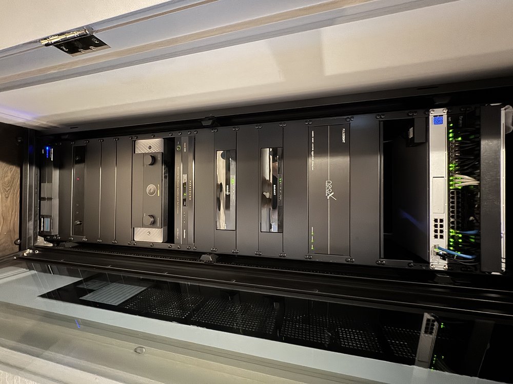 Extensive professional equipment rack installation mounted in ceiling cavity showing premium AV and