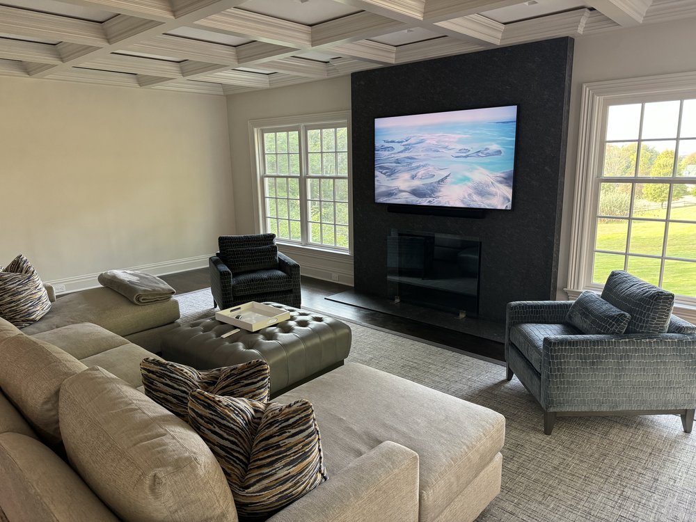 Secondary or guest bedroom featuring distinctive coffered ceiling design, marble fireplace surround,