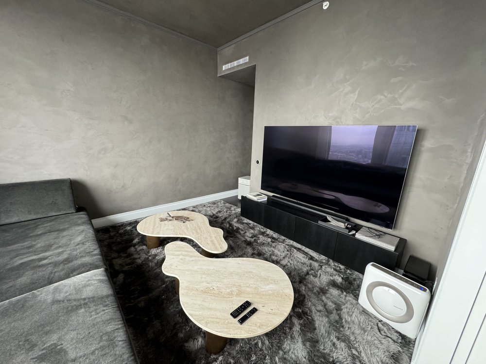 In-progress modern studio or bedroom space with raw concrete walls showing installation preparation. Features