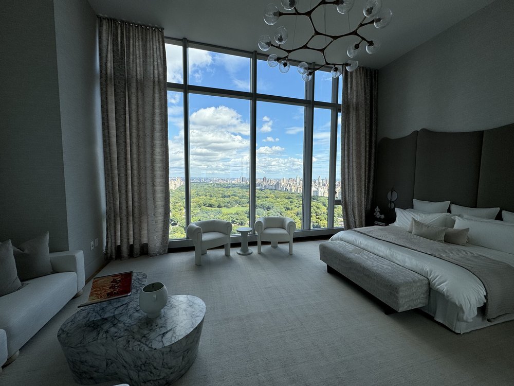 Stunning master bedroom overlooking Central Park with expansive views of trees and Manhattan skyline. The